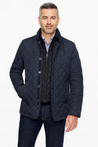 Man wearing a navy quilted jacket on a white background