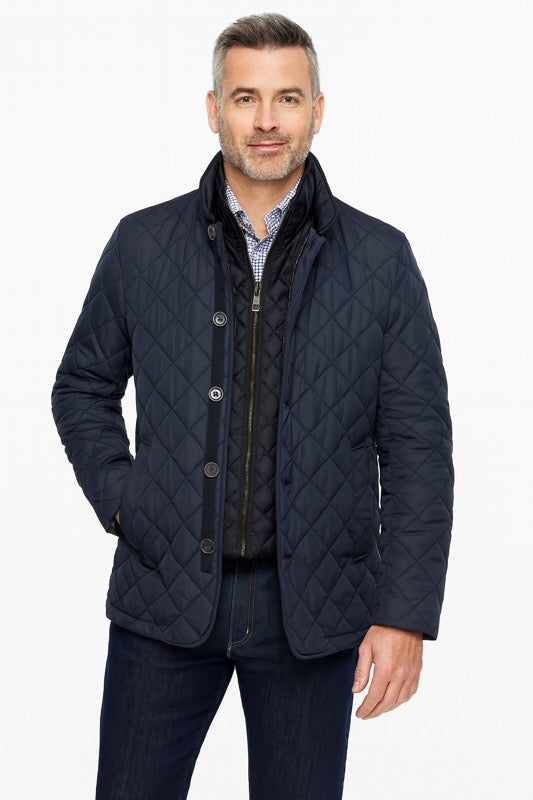 Man wearing a navy quilted jacket on a white background